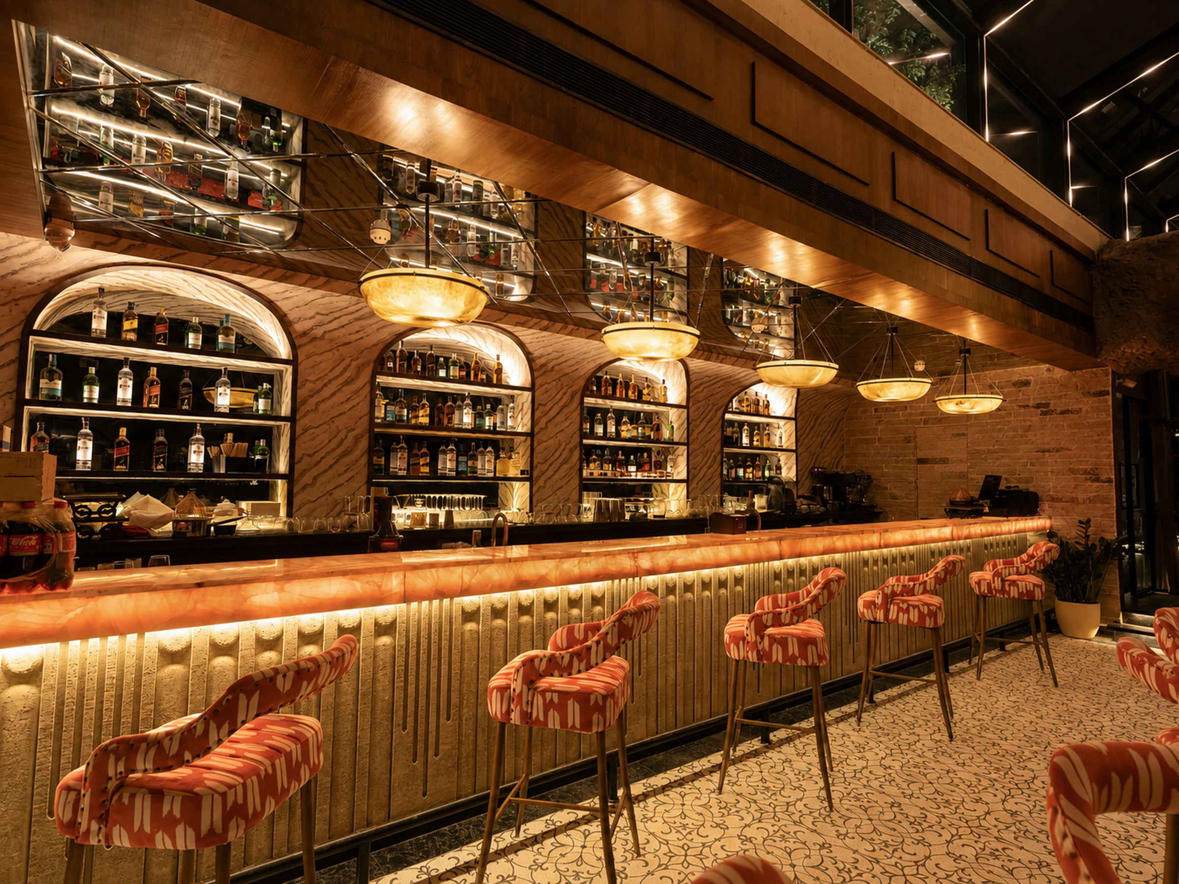 The long bar — arched shelves of bottles over a fluted counter and ikat bar stools