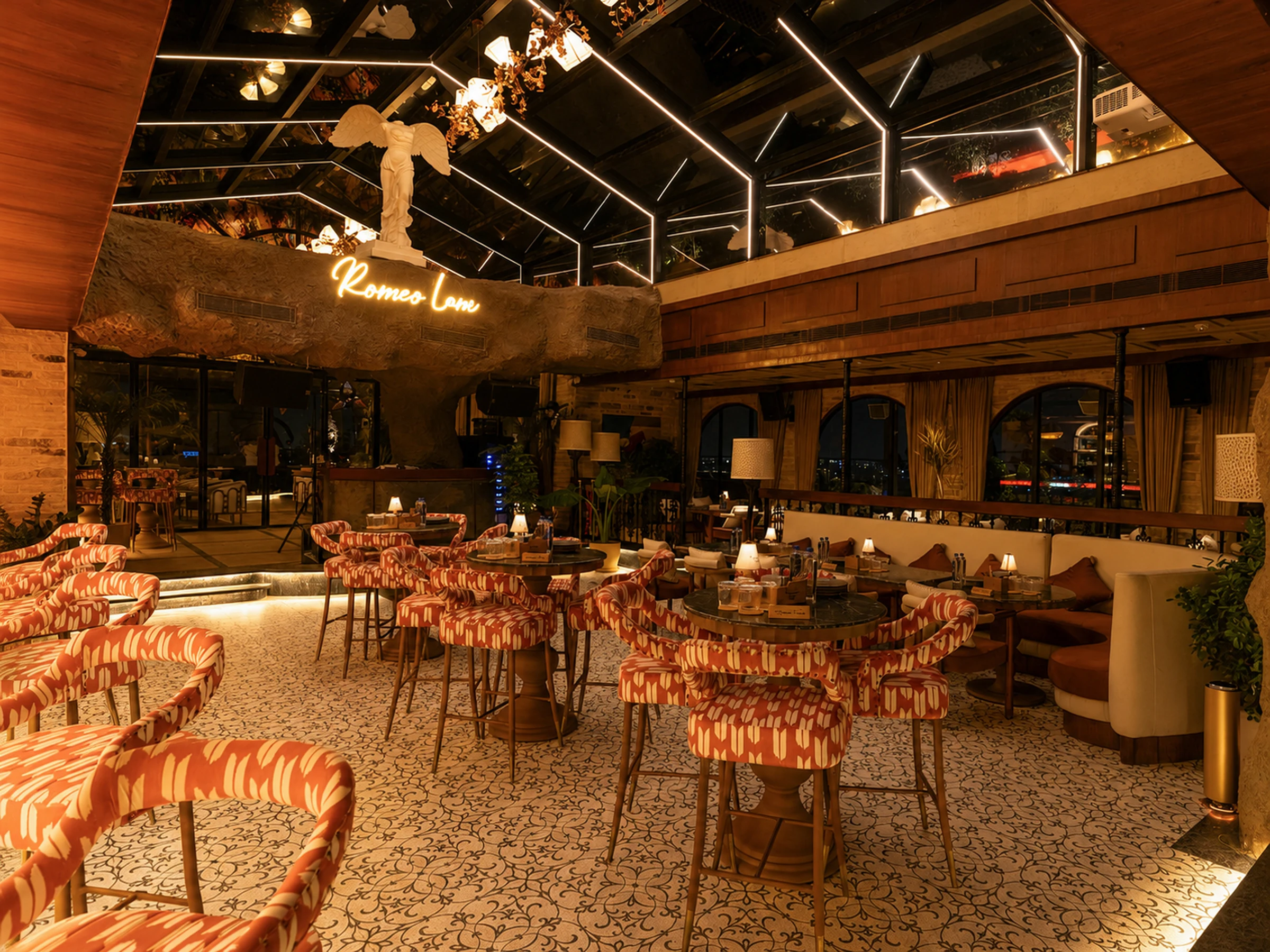 The glasshouse at night, the bar glowing along one side