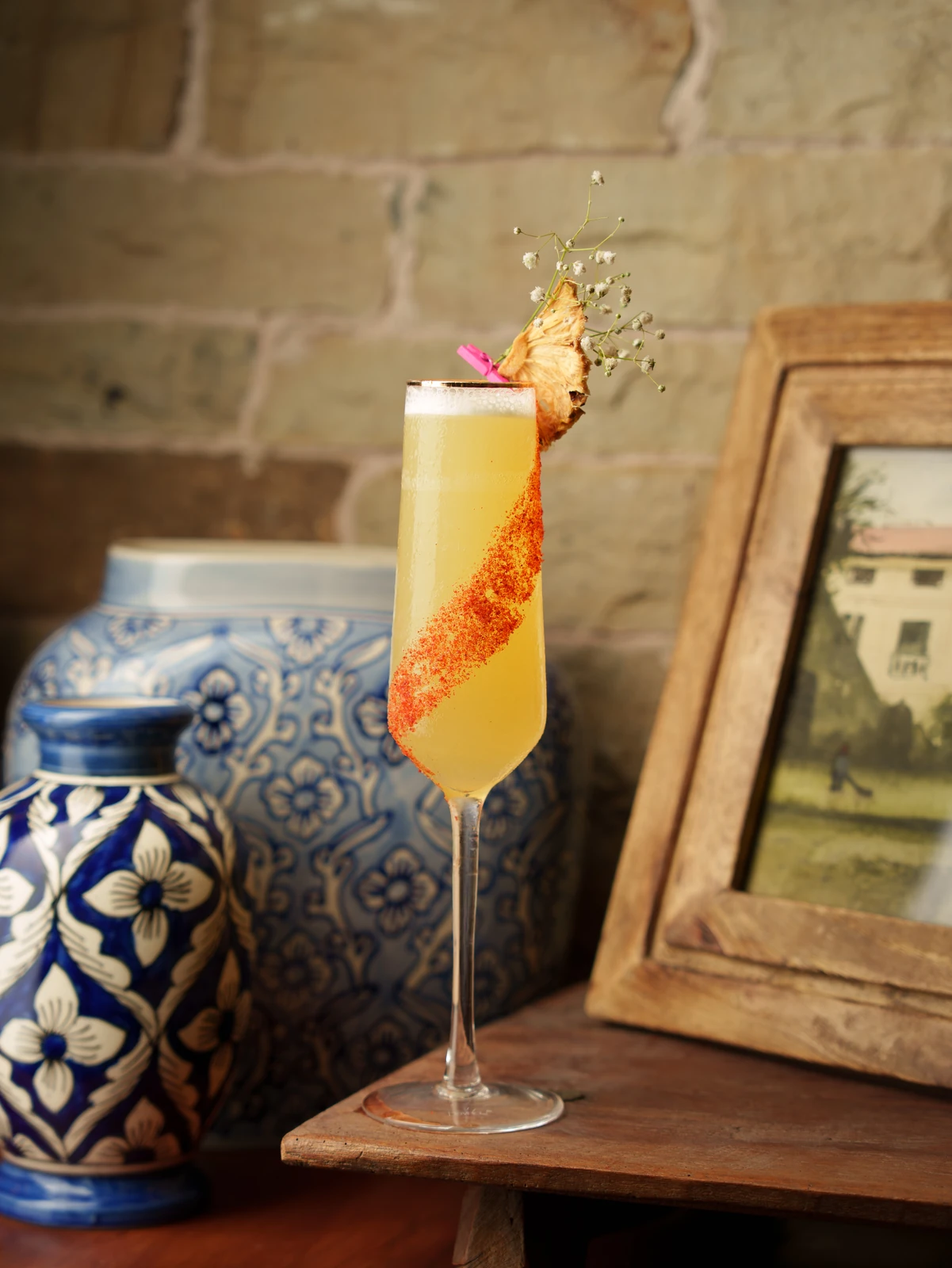 A champagne flute beside blue pottery