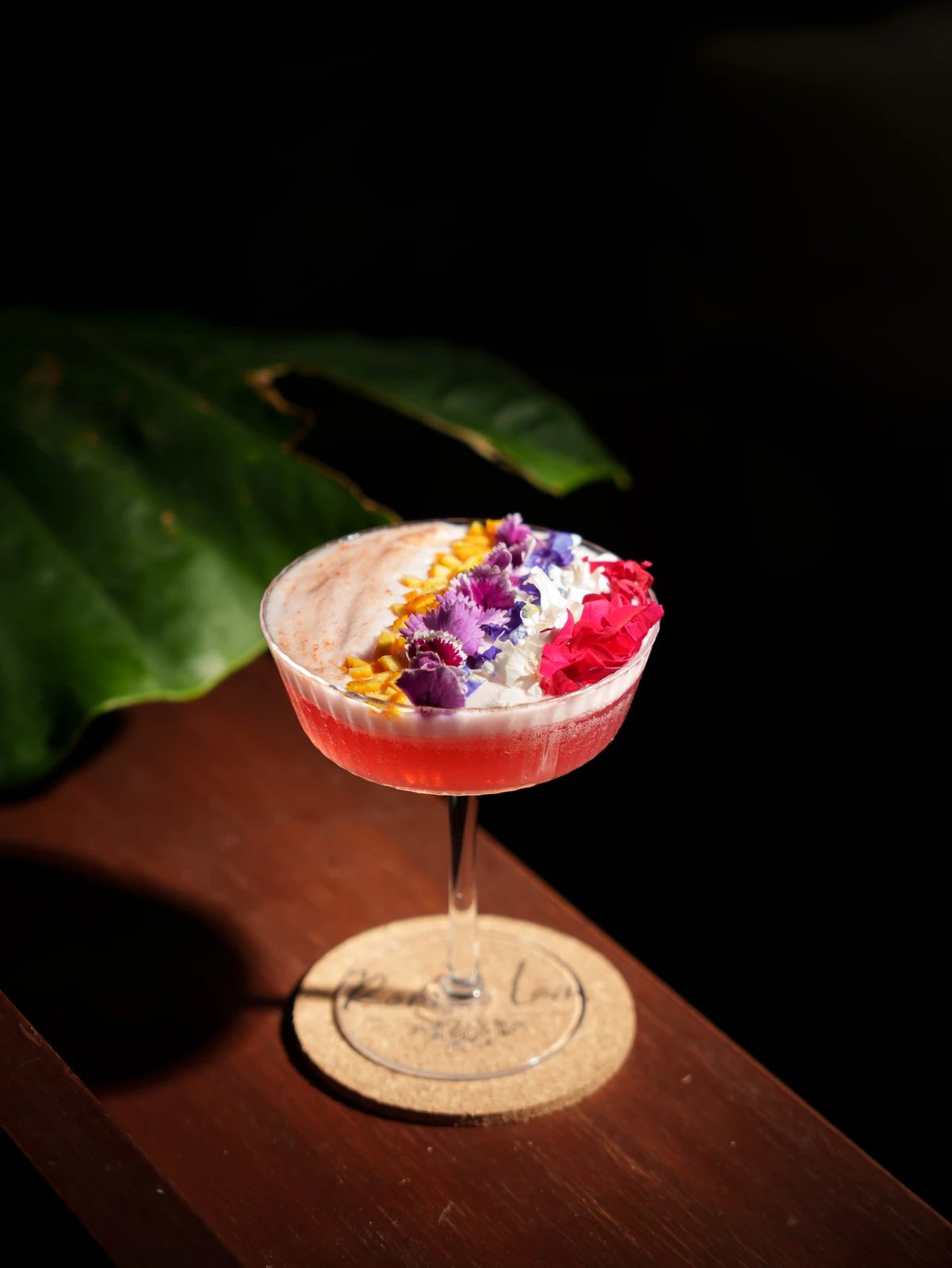 A flower-topped coupe on its coaster